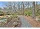 Tranquil stone pathway amid lush greenery, enhancing this home's peaceful, landscaped backyard at 202 Firefly Ct, Peachtree City, GA 30269