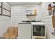 Laundry room featuring white shiplap walls, floating shelf and white front loading washer and dryer at 202 Firefly Ct, Peachtree City, GA 30269