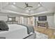 Main bedroom featuring a flat screen tv, modern lighting, tray ceilings, and entry to a bathroom at 202 Firefly Ct, Peachtree City, GA 30269