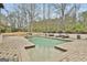 Beautiful backyard pool with lush landscaping, patio, and tanning deck, perfect for outdoor relaxation at 202 Firefly Ct, Peachtree City, GA 30269