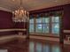 Formal dining room with chandelier, window, hardwood floors, and rich burgundy wallpaper at 101 Glen Eagle Way, Mcdonough, GA 30253
