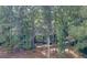 View of exterior with large trees surrounding home, multiple balconies, and stairs to main level at 101 Glen Eagle Way, Mcdonough, GA 30253
