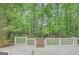 Backyard shed surrounded by green trees and grass with deck in the foreground at 180 Bentley Way, Fayetteville, GA 30214