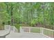 Backyard shed surrounded by green trees and grass with deck in the foreground at 180 Bentley Way, Fayetteville, GA 30214