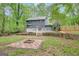 A beautiful backyard with a patio connected to the house, fire pit, and surrounding trees and nature at 180 Bentley Way, Fayetteville, GA 30214