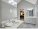 Bright bathroom boasts double vanity, large mirrors, and sleek gray wood-look flooring at 180 Bentley Way, Fayetteville, GA 30214