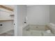 Bright bathroom featuring a drop-in bathtub, an orchid flower, and an open closet at 180 Bentley Way, Fayetteville, GA 30214