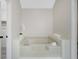 Bright bathroom featuring a drop-in bathtub, an orchid flower, and white towels at 180 Bentley Way, Fayetteville, GA 30214