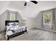 Bright bedroom with slanted ceiling, built-in shelves, and large double-paned windows at 180 Bentley Way, Fayetteville, GA 30214