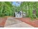 Front exterior of the house with a long driveway surrounded by trees at 180 Bentley Way, Fayetteville, GA 30214