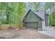 Side view of the house showing the gray garage and driveway surrounded by trees at 180 Bentley Way, Fayetteville, GA 30214