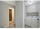 Hallway view of the laundry room featuring a Whirlpool washer and dryer set with ample cabinet space at 180 Bentley Way, Fayetteville, GA 30214