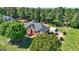 Aerial view of brick home with lush landscaping, a circular driveway, and large detached garage at 220 Edna Ruth Ln, Mcdonough, GA 30253