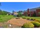 Scenic backyard featuring a stone firepit, brick patio, lush lawn, and mature trees at 220 Edna Ruth Ln, Mcdonough, GA 30253