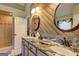 Stylish bathroom with wood accent wall, granite double vanity, and glass enclosed shower at 220 Edna Ruth Ln, Mcdonough, GA 30253