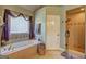 Bright bathroom featuring a tiled tub, ceramic floors and decorative accents and glass enclosed shower at 220 Edna Ruth Ln, Mcdonough, GA 30253