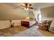 Bedroom featuring an angled ceiling, ceiling fan, sleigh bed, and a cozy sitting area with a soft chair at 220 Edna Ruth Ln, Mcdonough, GA 30253