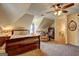 Bedroom featuring an angled ceiling, ceiling fan, sleigh bed, and a cozy sitting area with a soft chair at 220 Edna Ruth Ln, Mcdonough, GA 30253