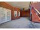 Inviting covered patio with brick accent wall, ceiling fan, and staircase access to upper level at 220 Edna Ruth Ln, Mcdonough, GA 30253