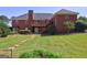 Rear exterior of brick home featuring a walkout basement, patio, and manicured lawn at 220 Edna Ruth Ln, Mcdonough, GA 30253