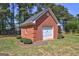 Detached brick garage with white door and landscaped garden at 220 Edna Ruth Ln, Mcdonough, GA 30253