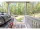 View of a back porch with wooden deck, grill, and view of the wooded lawn at 120 Trisha Ln, Grantville, GA 30220
