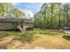 A large, grassy backyard with scattered trees, featuring a playset and trampoline at 120 Trisha Ln, Grantville, GA 30220