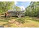 A spacious backyard features a playset and provides ample green space, bordered by trees at 120 Trisha Ln, Grantville, GA 30220