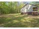 The exterior of the home features a back porch and sprawling lawn with large, mature trees at 120 Trisha Ln, Grantville, GA 30220