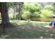 Spacious backyard featuring a rustic fire pit surrounded by lush greenery, a wooden fence, and mature trees at 4793 Davenport Nw Trce, Acworth, GA 30101