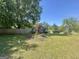 Home featuring a spacious lawn, mature trees, landscaping, and a blue truck parked in the driveway at 4793 Davenport Nw Trce, Acworth, GA 30101