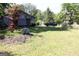 Home featuring a spacious lawn, mature trees, landscaping, and a blue truck parked in the driveway at 4793 Davenport Nw Trce, Acworth, GA 30101