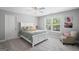 Cozy bedroom with a white bed frame, large window, plush chair, and neutral decor at 189 Willowleaf Way, Sharpsburg, GA 30277