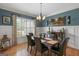 Elegant dining room featuring wainscoting, a chandelier, and a window with shutters at 189 Willowleaf Way, Sharpsburg, GA 30277