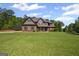 Two-story home on a large lawn with mature trees, detailed trim, and a walkway to the front door at 189 Willowleaf Way, Sharpsburg, GA 30277