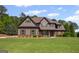 Two-story home on a well-manicured lawn with mature trees, detailed trim and warm brown accents at 189 Willowleaf Way, Sharpsburg, GA 30277
