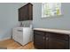 Practical laundry room with washer, dryer, ample counter space and storage at 189 Willowleaf Way, Sharpsburg, GA 30277