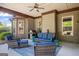 Covered outdoor patio with wicker furniture, ceiling fan, grill, and wood paneled walls at 189 Willowleaf Way, Sharpsburg, GA 30277