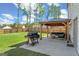 Large backyard with a covered patio, outdoor seating, and a grill, ideal for outdoor gatherings at 150 Ivy Chase Loop, Dallas, GA 30157