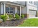 Charming front porch with seating, lush landscaping, and stylish front door enhance curb appeal at 150 Ivy Chase Loop, Dallas, GA 30157