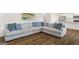 Spacious living room features hardwood floors and a comfortable sectional sofa at 150 Ivy Chase Loop, Dallas, GA 30157