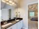 Bathroom featuring a double sink vanity with granite countertops and entry view to bedroom with trey ceiling at 30 Saint Charles Pl, Sharpsburg, GA 30277