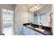 Bathroom featuring double sink vanity with black countertop and access to the laundry area at 30 Saint Charles Pl, Sharpsburg, GA 30277