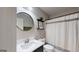 Bathroom featuring single sink vanity, round mirror, picture on shelf, and shower with curtain at 30 Saint Charles Pl, Sharpsburg, GA 30277