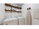 Laundry room featuring side-by-side washer and dryer, wood shelving, and an ironing board at 30 Saint Charles Pl, Sharpsburg, GA 30277