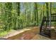 Tranquil backyard view with wooded area, stairs to deck, and mature trees at 4448 Janice Dr, Snellville, GA 30039