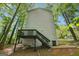 Exterior view of back of home with wooden deck/stairs and surrounded by mature trees at 4448 Janice Dr, Snellville, GA 30039
