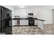 Classic kitchen featuring white cabinets, black appliances, and sleek countertops, blending style with functionality at 4448 Janice Dr, Snellville, GA 30039
