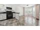 Open-concept kitchen featuring white cabinets, black appliances and countertops, seamlessly connected to a dining area at 4448 Janice Dr, Snellville, GA 30039