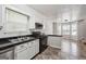 Well-lit kitchen featuring white cabinets, black appliances and countertops, enhanced by natural light and updated fixtures at 4448 Janice Dr, Snellville, GA 30039